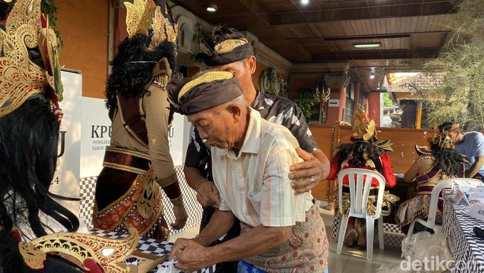 Ketut Korja saat menggunakan hak pilihnya di TPS 11 Penarungan, Rabu (27/11/2024).
