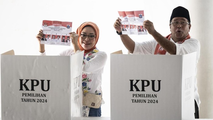 Calon Wakil Gubernur Jakarta nomor urut tiga Rano Karno (kanan) bersama istrinya Dewi Indriati (kiri) menunjukkan surat suara saat menggunakan hak pilihnya di TPS 065 Lebak Bulus, Cilandak, Jakarta, Rabu (27/11/2024). Komisi Pemilihan Umum (KPU) menetapkan pemungutan suara Pilkada 2024 berlangsung serentak pada 27 November 2024. ANTARA FOTO/Aprillio Akbar/aww.