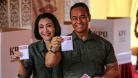 Andika dan istri kompak melempar senyuman usai melakukan pencoblosan. 