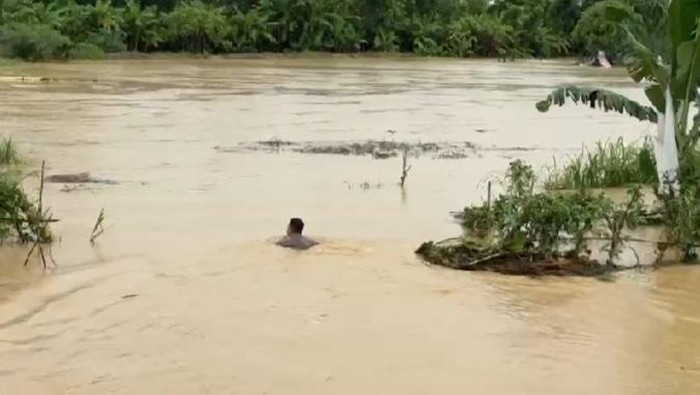 Briptu Johannes saat berenang mengevakuasi lansia terjebak banjir. (Dok. Istimewa)