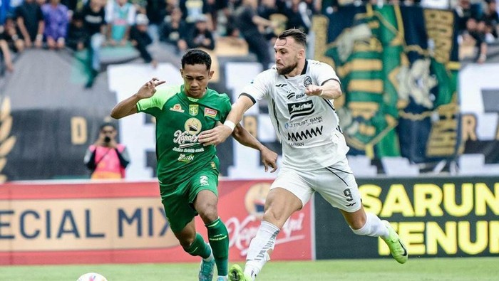 Catur Pamungkas berebut bola dengan pemain Persija Marco Simic