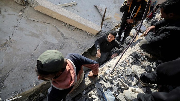 Palestinians search for casualties trapped under the rubble of a school sheltering displaced people, following an Israeli strike, amid the Israel-Hamas conflict, in Gaza City November 27, 2024. REUTERS/Dawoud Abu Alkas