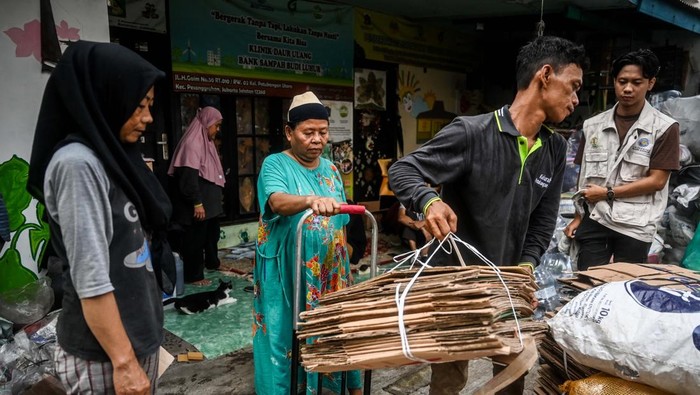 Pekerja membawa karung berisi sampah plastik untuk didaur ulang menjadi bahan kerajinan di rumah produksi Bank Sampah Budi Luhur, Tangerang.