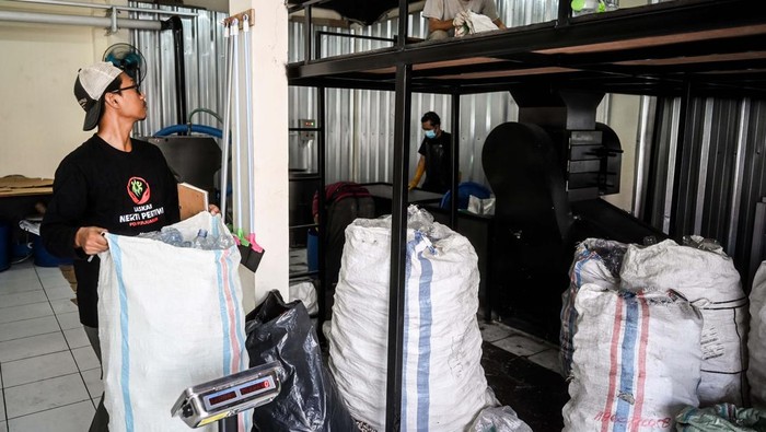 Pekerja membawa karung berisi sampah plastik untuk didaur ulang menjadi bahan kerajinan di rumah produksi Bank Sampah Budi Luhur, Tangerang.