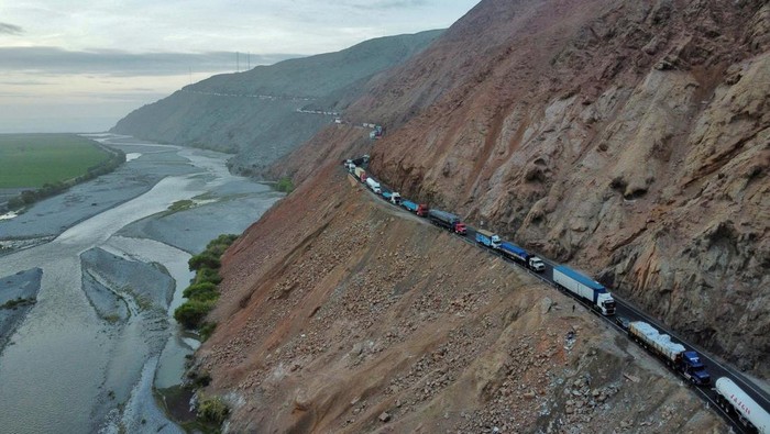 People stand next to their cars and other vehicles as small-scale miners halt traffic to demand the extension of a program that allows them to operate temporarily, but which authorities say has expanded illegal mining, in Ocona, Peru November 27, 2024. REUTERS/Oswald Charca      TPX IMAGES OF THE DAY