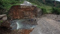 Kondisi jalan yang terputus akibat longsor dan jembatan terbawa arus sungai di Desa Hambalang, Kabupaten Bogor, Jawa Barat, Kamis (28/11/2024).