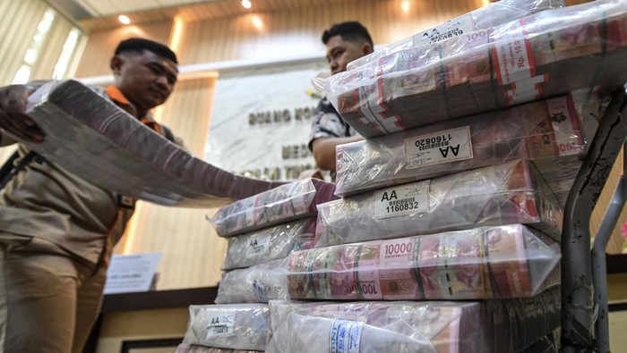 Penyerahan barang bukti kasus korupsi LRT di Palembang Petugas membawa barang bukti sitaan berupa uang pada tahap II penyerahan tersangka dan barang bukti di kantor Kejaksaan Tinggi (Kejati) Provinsi Sumatera Selatan, Palembang, Sumatera Selatan, Kamis (28/11/2024). Kejati Sumatera Selatan menyita barang bukti uang senilai Rp22,5 miliar dari tersangka Direktur Utama PT Parentjana Djaja Bambang Hariyadi Wikanta yang merupakan tersangka dugaan tindak pidana korupsi pembangunan prasarana Light Rail Transit (LRT) Sumatera Selatan pada satuan kerja pengembangan, peningkatan dan perawatan prasarana perekeretaapian Kementerian Perhubungan tahun anggaran 2016-2020. ANTARA FOTO/Nova Wahyudi/Spt.
