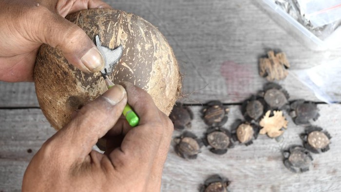 Perajin menunjukkan liontin kalung yang berbahan dasar batok kelapa di Pulau Maratua, Berau, Kalimantan Timur, Rabu (27/11/2024). Kerajinan seharga Rp20 ribu hingga Rp35 ribu per buah yang telah diekspor hingga Ceko tersebut merupakan bagian dari program ekonomi biru hasil pendampingan Yayasan Konservasi Alam Nusantara (YKAN) pada Kelompok Sadar Wisata (Pokdarwis) Teluk Harapan. ANTARA FOTO/M Risyal Hidayat/nym.