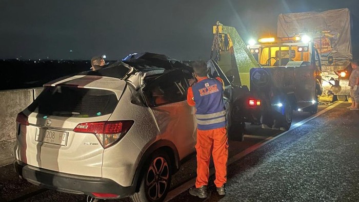 Petugas mengevakuasi kendaraan HRV di Tol Krian-Bunder, Gresik.