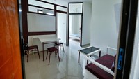 Fasilitas di dalamnya juga cukup lengkap. Terlihat pada gambar terdapat ruang tamu. Di dalamnya terdapat beberapa bangku dan meja.