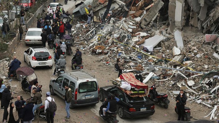 People gather as cars drive past rubble from damaged buildings in Beirut's southern suburbs, after a ceasefire between Israel and Iran-backed group Hezbollah took effect at 0200 GMT on Wednesday after U.S. President Joe Biden said both sides accepted an agreement brokered by the United States and France, in Lebanon, November 27, 2024. REUTERS/Mohamed Azakir