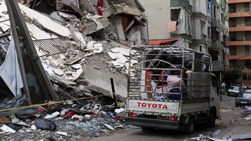 People gather as cars drive past rubble from damaged buildings in Beiruts southern suburbs, after a ceasefire between Israel and Iran-backed group Hezbollah took effect at 0200 GMT on Wednesday after U.S. President Joe Biden said both sides accepted an agreement brokered by the United States and France, in Lebanon, November 27, 2024. REUTERS/Mohamed Azakir