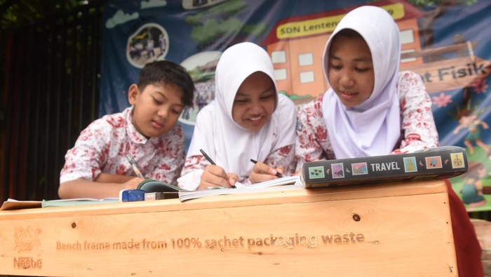 Tiga murid belajar menggunakan bangku daur ulang plastik pasca konsumsi di SDN Lenteng Agung 09, Jakarta, Jumat (29/11/2024). Nestle Indonesia meluncurkan program distribusi 5.000 bangku daur ulang berbahan plastik pasca konsumsi ke sekolah dasar di Jakarta, Bandung, Bogor, dan Bandar Lampung sebagai langkah mengurangi limbah sampah plastik di Indonesia. ANTARA FOTO/Indrianto Eko Suwarso/rwa.