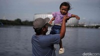 Seorang pria dan anak kecil bermain di sekitar JIS.