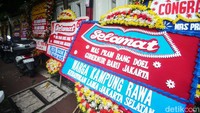 Karangan bunga itu nampak meluber hingga ke depan rumah warga. 