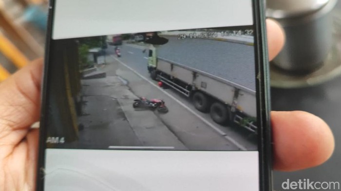Warga menunjukkan rekaman CCTV pemotor masuk ke kolong truk di Purwosari, Pasuruan