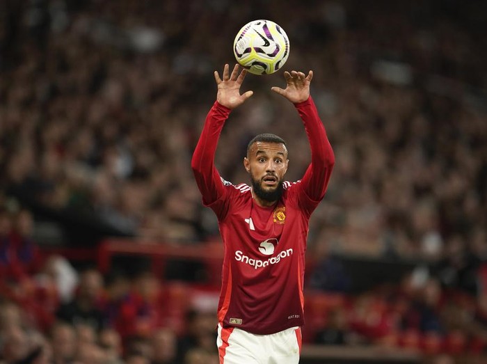 Manchester United's Noussair Mazraoui takes a throw-in during the English Premier League soccer match between Manchester United and Fulham at Old Trafford, Friday, Aug. 16, 2024, in Manchester, England. (AP Photo/Dave Thompson)