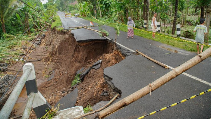 Foto udara sejumlah kendaraan melintasi jalan yang nyaris longsor di Desa Bantur, Kabupaten Malang, Jawa Timur, Jumat (29/11/2024). Berdasarkan hasil identifikasi sementara Badan Penanggulangan Bencana Daerah (BPBD) Kabupaten Malang, enam titik banjir dan empat titik tanah longsor yang tersebar di enam kecamatan pada Kamis (28/11) tersebut menyebabkan 82 KK atau 283 Jiwa terdampak serta delapan rumah dan tiga jembatan rusak. ANTARA FOTO/Irfan Sumanjaya/tom.
