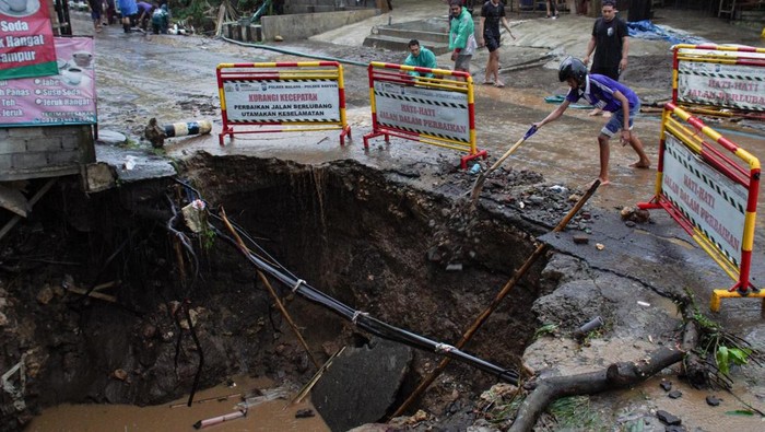 Potret Dampak Banjir dan Longsor di Kabupaten Malang Foto udara sejumlah kendaraan melintasi jalan yang nyaris longsor di Desa Bantur, Kabupaten Malang, Jawa Timur, Jumat (29/11/2024). Berdasarkan hasil identifikasi sementara Badan Penanggulangan Bencana Daerah (BPBD) Kabupaten Malang, enam titik banjir dan empat titik tanah longsor yang tersebar di enam kecamatan pada Kamis (28/11) tersebut menyebabkan 82 KK atau 283 Jiwa terdampak serta delapan rumah dan tiga jembatan rusak. ANTARA FOTO/Irfan Sumanjaya/tom.