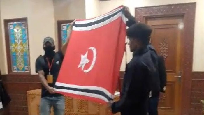 Pria bentangkan bendera bulan bintang di kantor Gubernur Aceh. (Istimewa)