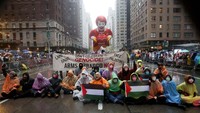 Orang-orang berunjuk rasa untuk mendukung warga Palestina di Gaza selama Parade Hari Thanksgiving Macys ke-98 di New York, AS, Kamis (28/11). 