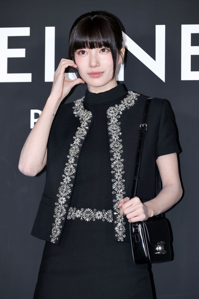 Bae Suzy tampil mempesona dengan riasan minimalis yang fokus pada kulit flawless dan sedikit rona pink pada bibir. Rambutnya ditata dengan poni dan diikat rapi, memperkuat kesan klasik dan chic. Foto: WireImage/Han Myung-Gu