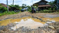 Pengendara sepeda motor melintasi jalan yang rusak di Cikadu, Kabupaten Cianjur, Jawa Barat, Sabtu (30/11/2024).