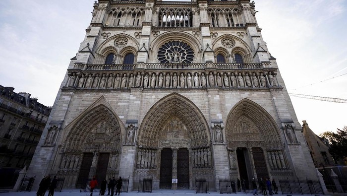 People stand outside Notre-Dame Cathedral in Paris, Friday Nov. 29 2024 before French President Emmanuel Macron's final visit to the construction site to see the restored interiors before the iconic monument's reopening for worship on Dec. 8. (Sarah Meyssonnier, Pool via AP)