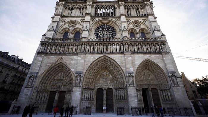 Katedral Notre-Dame Dibuka Lagi, Keindahannya Kini Lebih Memukau People stand outside Notre-Dame Cathedral in Paris, Friday Nov. 29 2024 before French President Emmanuel Macron's final visit to the construction site to see the restored interiors before the iconic monument's reopening for worship on Dec. 8. (Sarah Meyssonnier, Pool via AP)