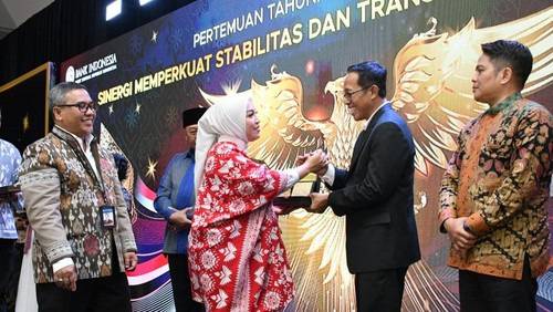 Pj Bupati Lombok Timur Muhammad Juaini Taofik (jas hitam) menerima penghargaan dari Deputi Kepala Perwakilan Kantor BI NTB Winda Putri Listypada di Mataram, Jumat (29/11/2024).