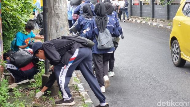 Pelajar yang melakukan plogging dengan garis start dan finis di Lapangan Widoro Kandang, Kotabaru, Gondokusuman, Kota Jogja, Sabtu (30/11/2024).