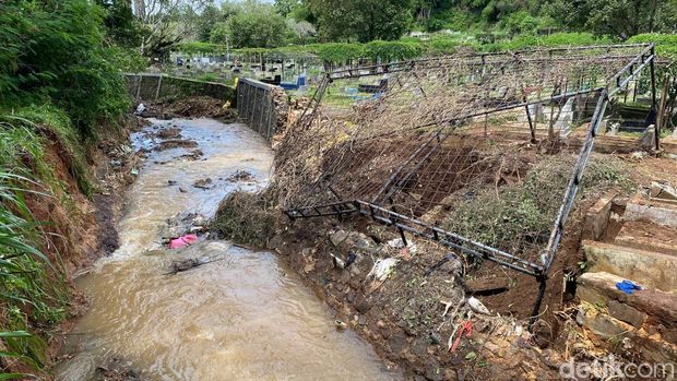 Penampakan tanggul jebol di TMP Cikutra Bandung yang ditimbulkan kerusakan banyak makam.