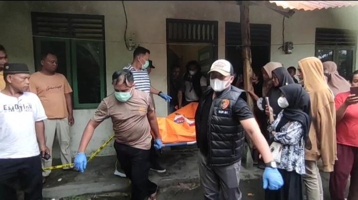 Polisi mengevakuasi biduan transgender yang ditemukan tewas di dalam rumah kontrakannya di Kisaran, Kabupaten Asahan. (dok. Istimewa)