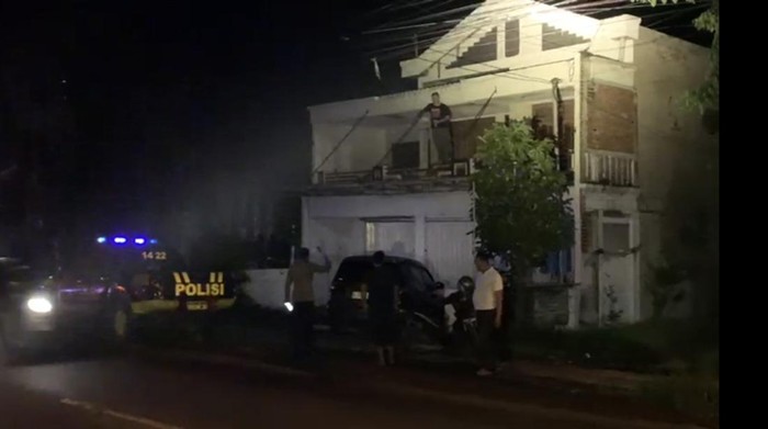Polisi saat berusaha bernegosiasi dengan bule di rumah kontrakan Putat Lor, Menganti Gresik