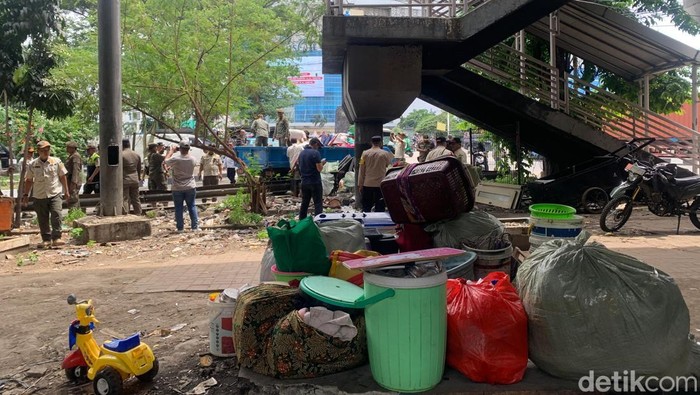 Proses relokasi warga penghuni kolong Tol Angke ke rusun. Aparat membantu warga mengangkut barang (Mulia/detikcom)