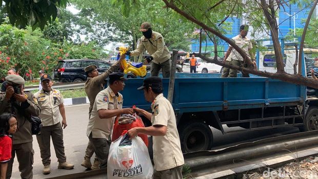 Proses relokasi warga penghuni kolong Tol Angke ke rusun. Aparat membantu warga mengangkut barang (Mulia/detikcom)