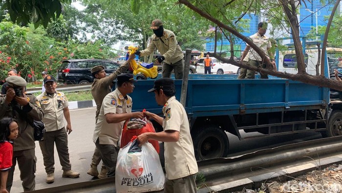 Sebanyak 44 keluarga akan direlokasi dari kolong Tol Angke ke Rusun Lokbin Rawa Buaya hari ini. Petugas Satpol PP membantu proses pemindahan tersebut. (Mulia Budi/detikcom)