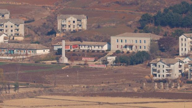 Warga Korea Utara berjalan di desa propaganda Korea Utara Kaepoong, dalam gambar yang diambil dari puncak Observatorium Puncak Aegibong, selatan zona demiliterisasi (DMZ), yang memisahkan kedua Korea di Gimpo, Korea Selatan, 29 November 2024. (REUTERS/Kim Soo-hyeon)