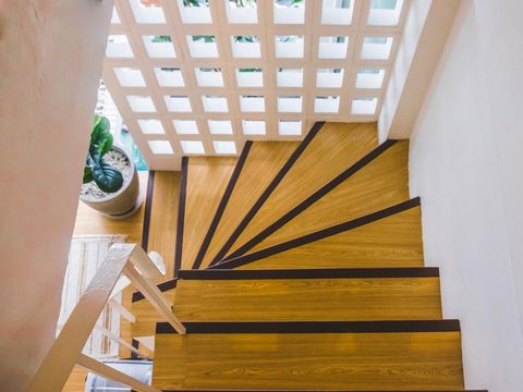 The modern two-storey bright apartment with wooden staircase. Interior of a modern living room with a staircase. Home building interior empty room design staircase concrete top wooden.
