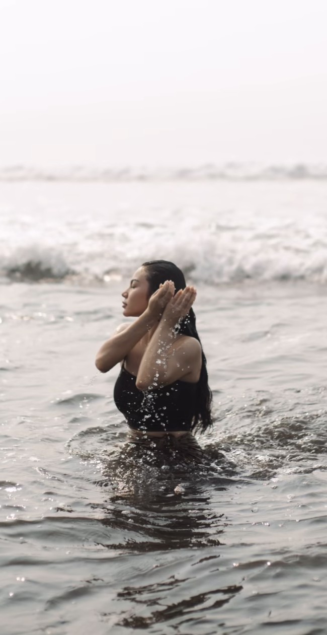 Mengenakan tanktop crop top tali spaghetti berwarna hitam dipadukan dengan kain lilit, Ariel tampak membasuh dirinya di laut. Foto: Instagram/@arieltatum