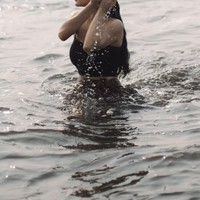 Mengenakan tanktop crop top tali spaghetti berwarna hitam dipadukan dengan kain lilit, Ariel tampak membasuh dirinya di laut. Foto: Instagram/@arieltatum