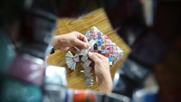 Perajin menyelesaikan pembuatan kerajinan tas berbahan baku dari daur ulang sampah plastik di kantor komunitas Gerakan Peduli Lingkungan (GPL) Desa Meureubo, Kecamatan Meureubo, Aceh Barat, Aceh, Minggu (1/12/2024).