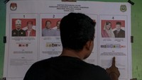 Warga melihat visi-misi pasangan calon Gubernur dan Wakil Gubernur yang di pajang pada pelaksanaan Pemungutan Suara Ulang (PSU) Pilkada 2024 untuk pemilihan Gubernur-Wakil Gubernur Maluku Utara di TPS 004 Kelurahan Kalumata, Ternate, Maluku Utara, Minggu (1/12/2024). KPU Kota Ternate menggelar PSU di TPS 004 atas rekomendasi Bawaslu karena ditemukan pelanggaran aturan Pilkada 2024 yaitu ditemukan 10 pemilih menggunakan KTP luar Ternate yang tidak terdaftar di dalam pemilih tetap dan daftar pemilih tambahan pada pencoblosan 27 November lalu. ANTARA FOTO/Andri Saputra. ANTARA FOTO/Andri Saputra.
