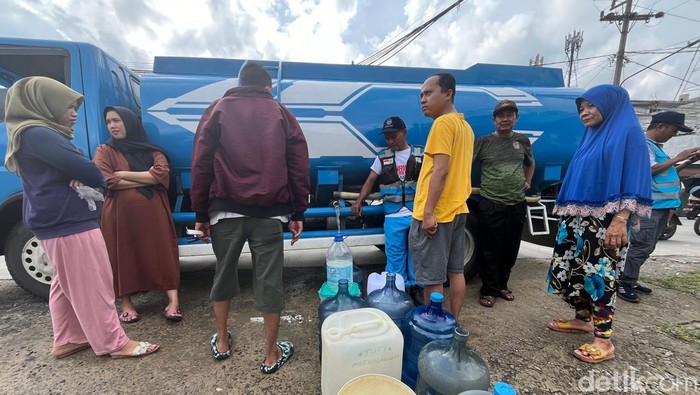 Sejumlah warga antre isi air dari tangki air Perumda Tirtanadi. (Kartika Sari/detikcom)