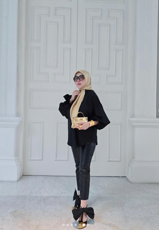Yang tak kalah bikin salfok ialah heels berbentuk unik yang juga dikenakan Syahrini. Heels tersebut memiliki bagian depan berwarna emas yang berbentuk menyerupai jari kaki. Warna emas itu dipadukan dengan warna hitam pada bagian tali dan pita yang cukup besar di pergelangan kakinya. Foto: Instagram/@princessyahrini