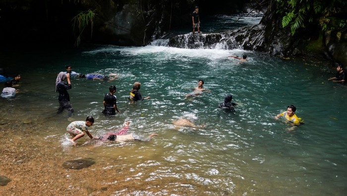 Sejumlah wisatawan bermain air di Curug Leuwi Mangrod, Desa Cibojong, Padarincang, Kabupaten Serang, Banten, Minggu (1/12/2024). Destinasi yang aliran airnya bersumber dari mata air Gunung Aseupan tersebut menawarkan berbagai wahana aktivitas luar ruangan yang berpotensi menjadi destinasi wisata unggulan dan dapat meningkatkan kunjungan pariwisata serta perekonomian masyarakat di kawasan itu. ANTARA FOTO/Putra M. Akbar/gp/YU