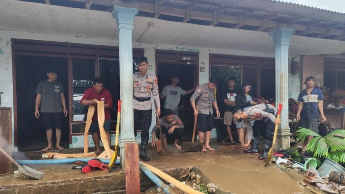 Anggota Polres Blitar bantu korban banjir.