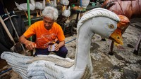 Perajin sedang membuat kerajinan berbahan dasar ban bekas di Kecamatan Kepanjen, Kabupaten Malang, Jawa Timur.
