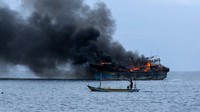 Kapal Tugboat berupaya memadamkan api pada Kapal Motor Nelayan (KMN) Bahtera di Selat Bali terlihat dari Pelabuhan Masami, Kalipuro, Banyuwangi, Jawa Timur, Senin (2/12/2024).