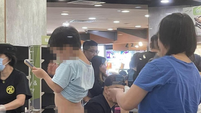Ibu mengganti popok anakya di tengah food court